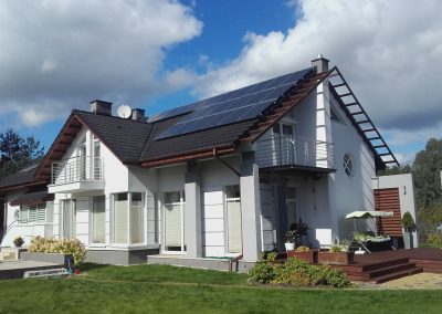 Ekonomiczny dom jednorodzinny z zamontowanym system instalacji fotowoltaicznym na dachu budynku. Energia oze źródłem dobrego środowiska.